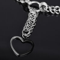 Silberne Herz Choker Kette aus Chirurgenstahl Silberne Choker Kette mit großem Herzanhänger auf schwarzem Hintergrund