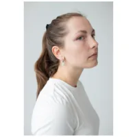 Frau mit langen Haaren trägt Little Daisy Hoops Ohrringe