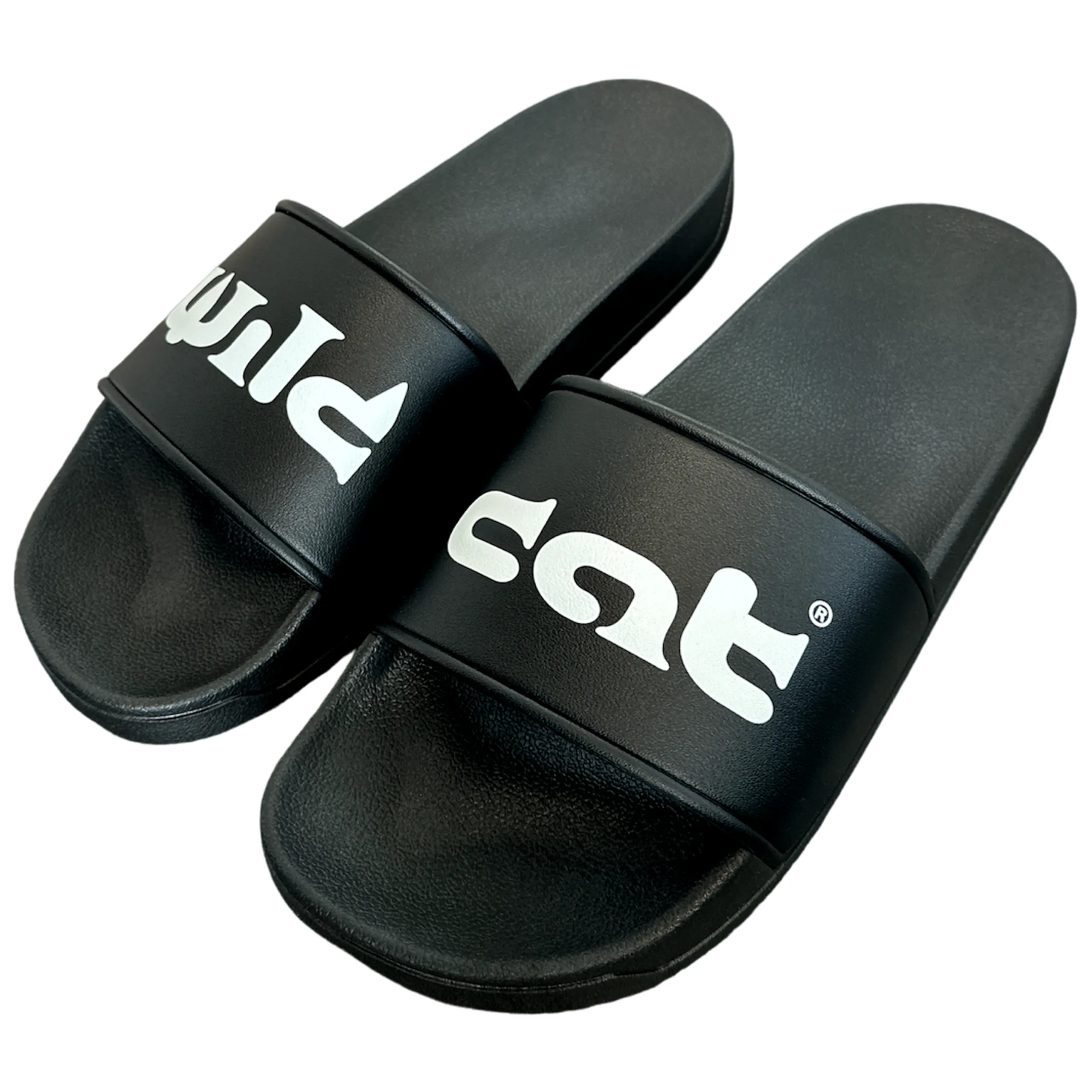 Schwarze Wildcat Slides mit Logo Schwarze PVC-Slides mit weißem Wildcat-Logo auf neutralem Hintergrund